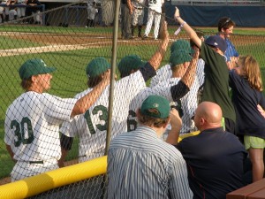 Young fans exchange high fives with Snappers players as they walk from their outfield pregame stretching to their dugout
