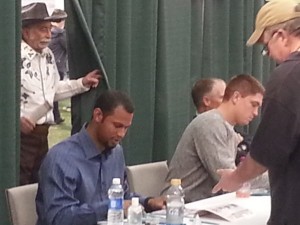 Twins prospects Aaron Hicks and Kyle Gibson at the autograph station, with Twins Clubhouse manager Wayne "Big Fella" Hattaway peeking in from behind the curtain