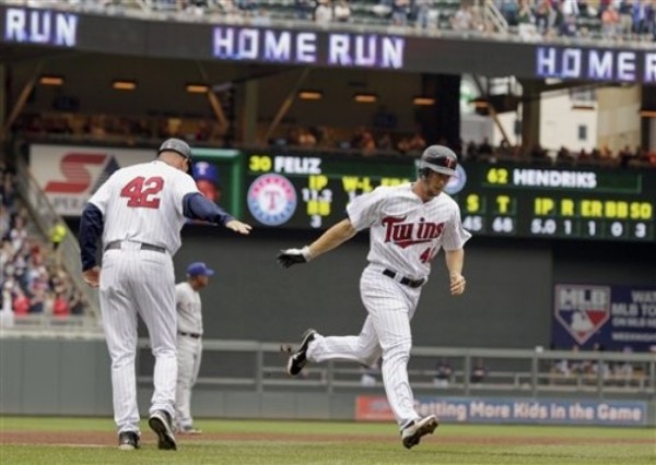 Minnesota Twins' Clete Thomas is congratulated by third base coach Steve Liddle, left, as he runs toward home plate on a two-run home run  against Texas Rangers pitcher Neftali during the fifth inning of a baseball game on Sunday, April 15, 2012, in Minneapolis. The players were all wearing No. 42 jerseys in honor of Jackie Robinson Day. (AP Photo/Genevieve Ross)