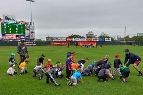 Blake Schmit and Randy LeBlanc teaching campers proper fielding position