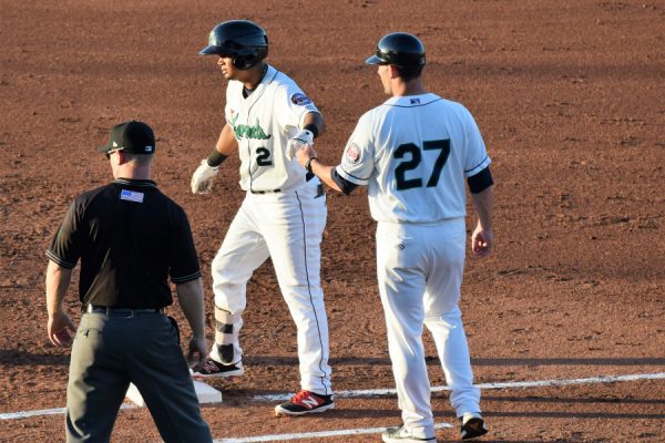 Luis Arraez had a pair of hits for the West squad. Here he's fist-bumped by Kernels coach Brian Dinkelman.